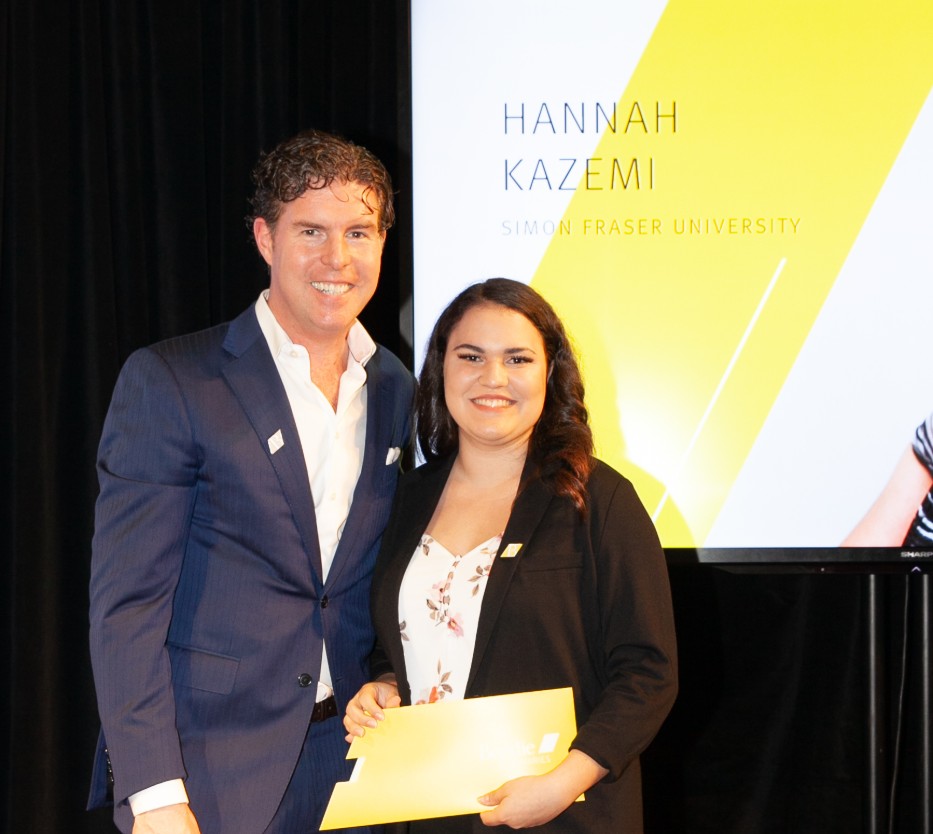 Ryan Beedie (left), standing next to Hannah Kazemi (right), holding a yellow certificate.