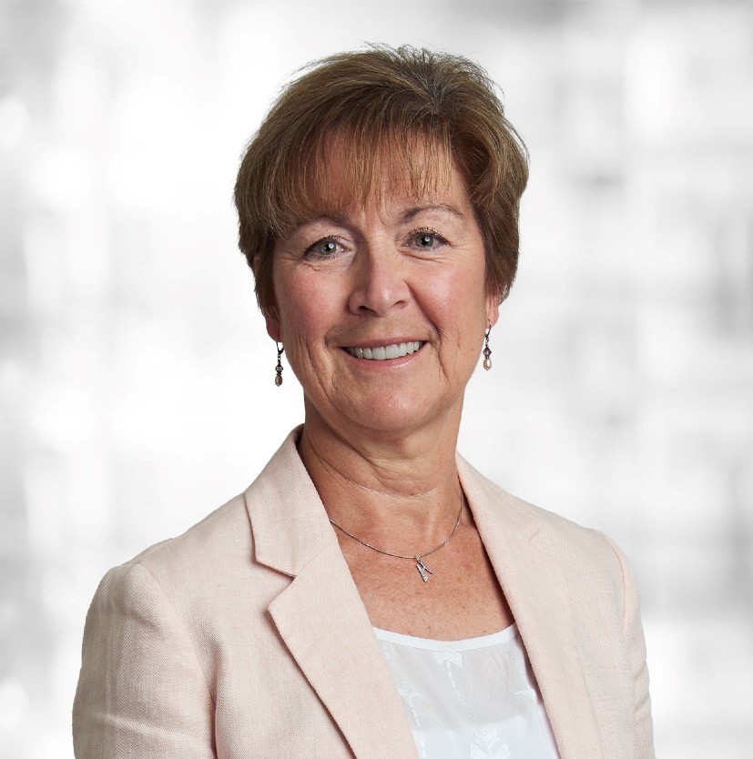 Women posing for a headshot in a beige blazer.