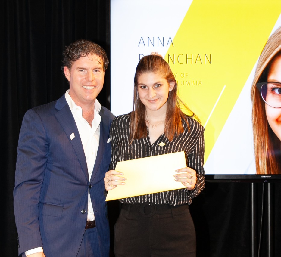 Ryan Beedie (left), standing next to Anna Riminchan (right), holding a yellow certificate.