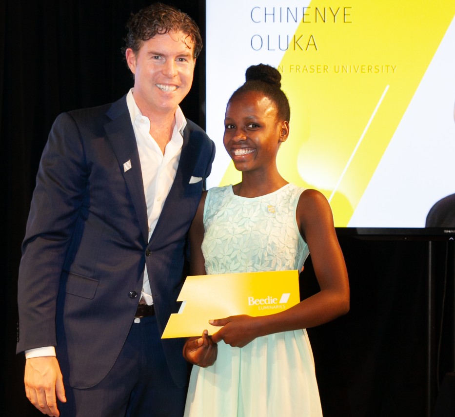 Ryan Beedie (left), standing next to Chinenye Oluka (right), holding a yellow certificate.