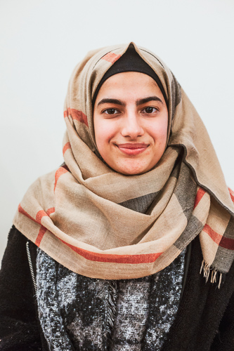 Hadil headshot in beige hijab, smiling gently.