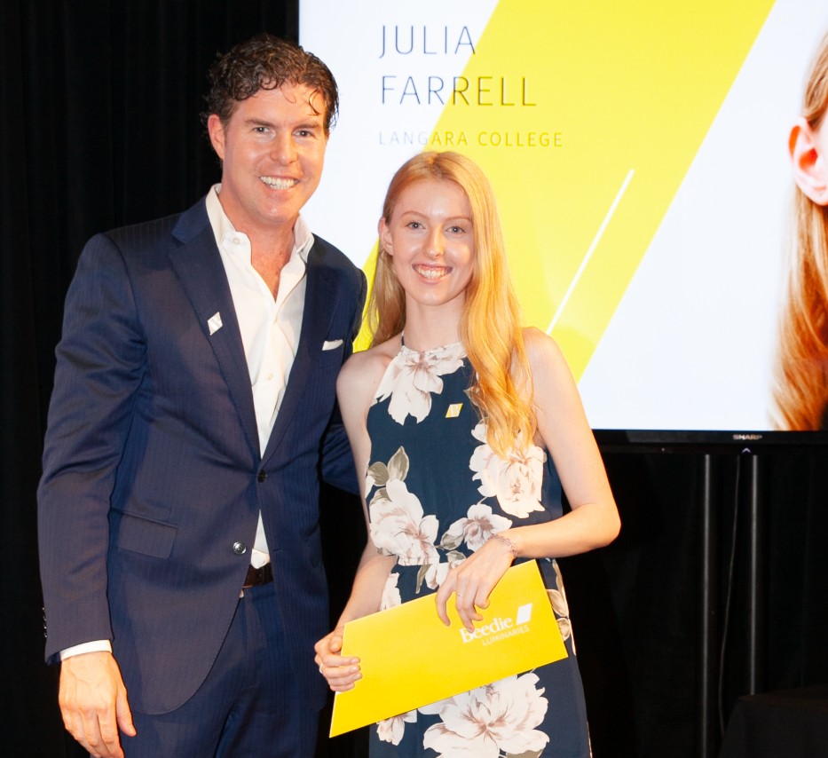 Ryan Beedie (left), standing next to Julia Farrell (right), holding a yellow certificate.