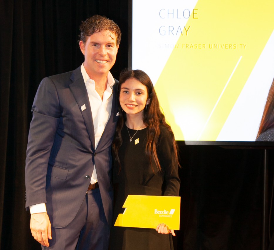 Ryan Beedie (left), standing next to Chloe Gray (right), holding a yellow certificate.