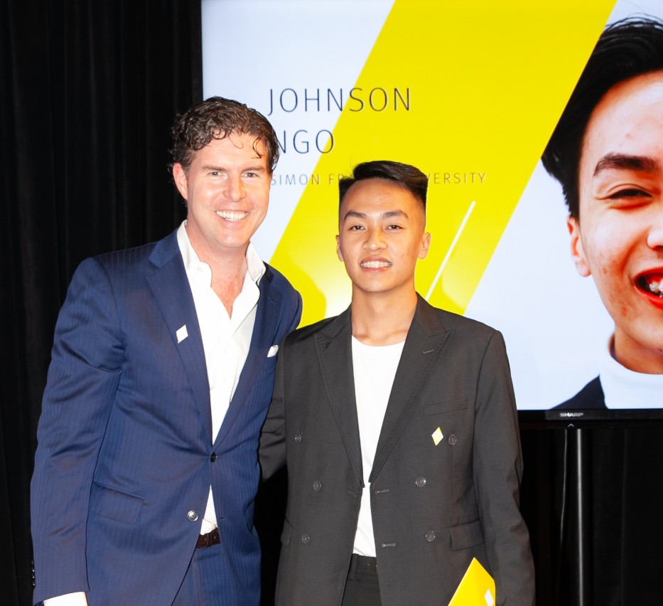 Ryan Beedie (left), standing next to Johnson Ngo (right), holding a yellow certificate.