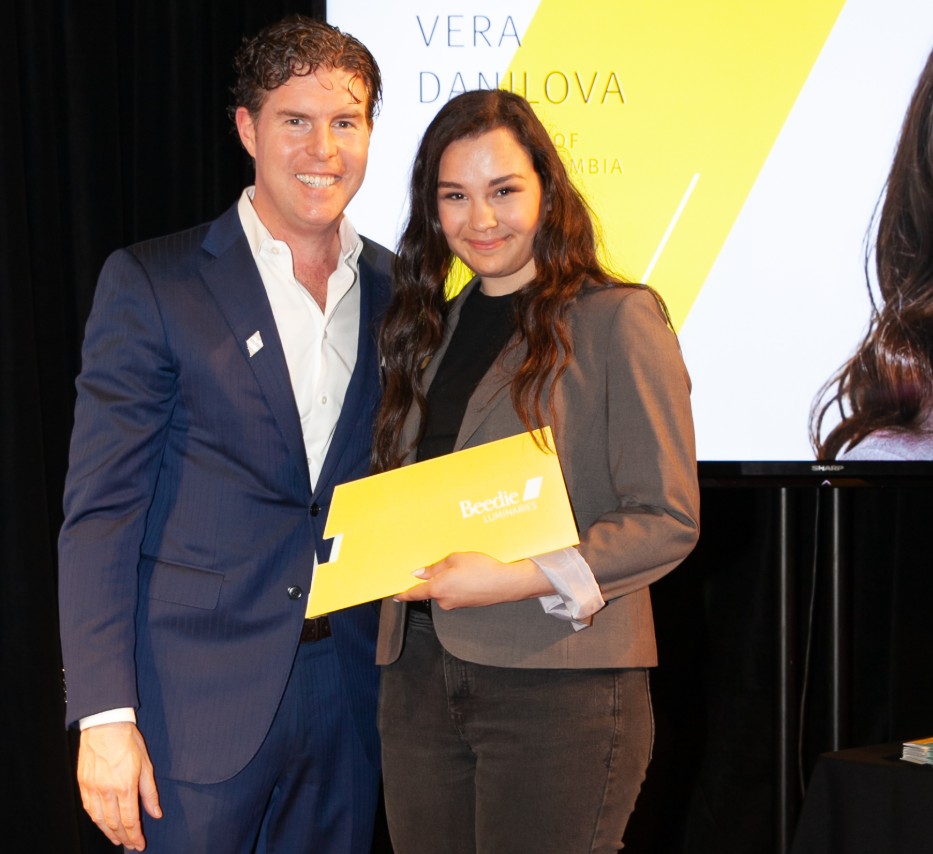Ryan Beedie (left), standing next to Vera Danilova (right), holding a yellow certificate.