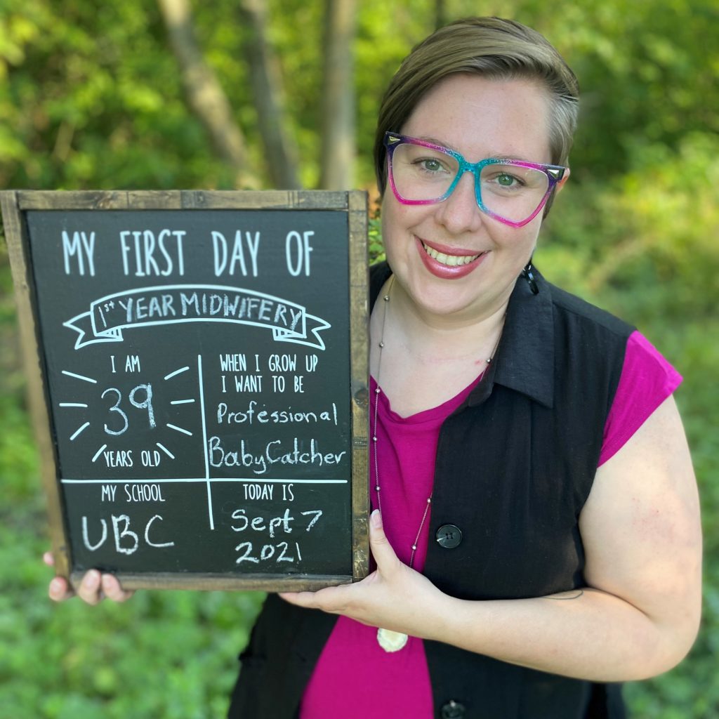 Avital Kline holding a sign for her first year of Midwifery at UBC