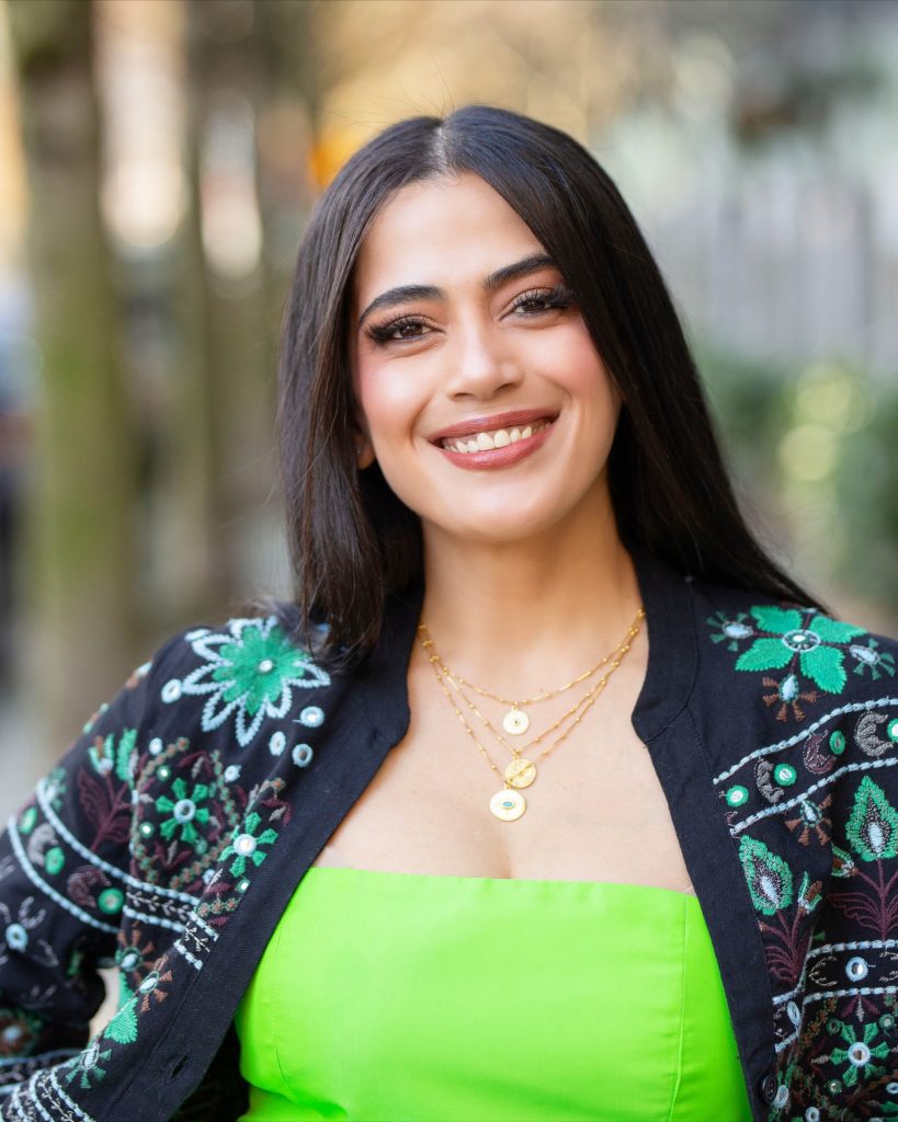 Suraya Tabesh headshot, wearing bright green top and patterned cardigan.