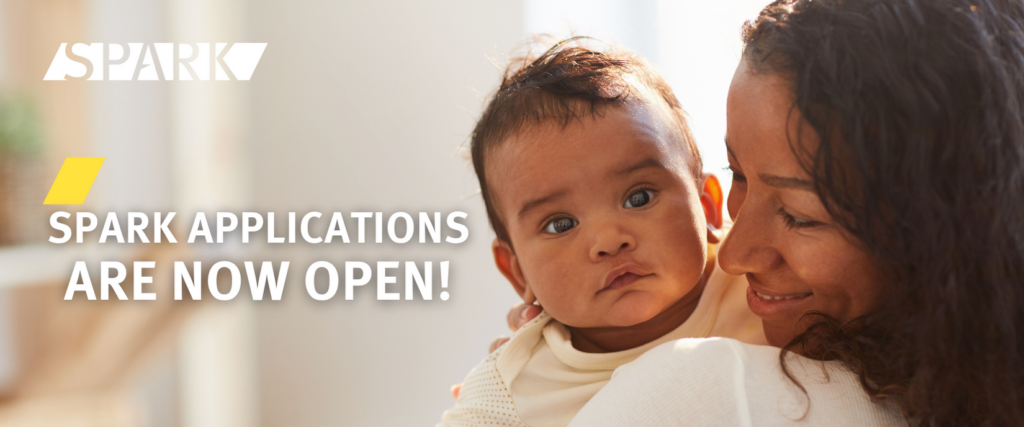 Mother holds newborn baby, with the words "SPARK APPLICATIONS ARE NOW OPEN" written atop of the image.